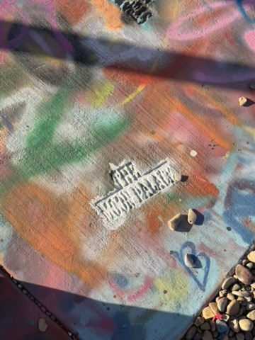 A Route 66 Mother Road stencil among layers of colorful paint