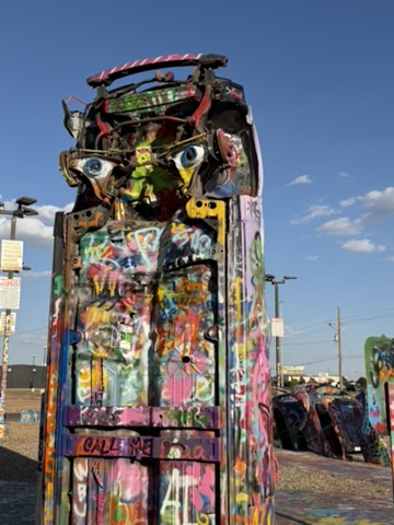 A brightly painted Volkswagen Beetle standing upright at Slug Bug Ranch